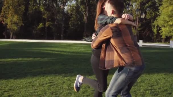 Vrouw loopt tot haar vriendje sprong met zijn handen en draai rond in slow motion — Stockvideo