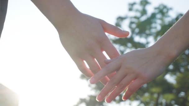 Пара тримає руки в сонячний день у повільному русі — стокове відео