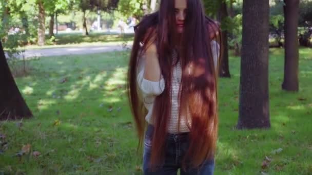 Mujer muestra su pelo muy largo en el parque — Vídeo de stock