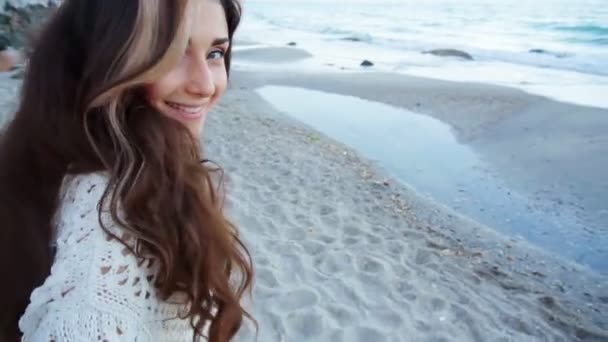 Молодая красивая женщина ходит по песку возле океана — стоковое видео