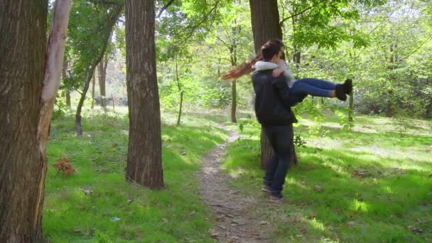Чоловік бере свою дівчину на руки і обертається в повільному русі — стокове відео