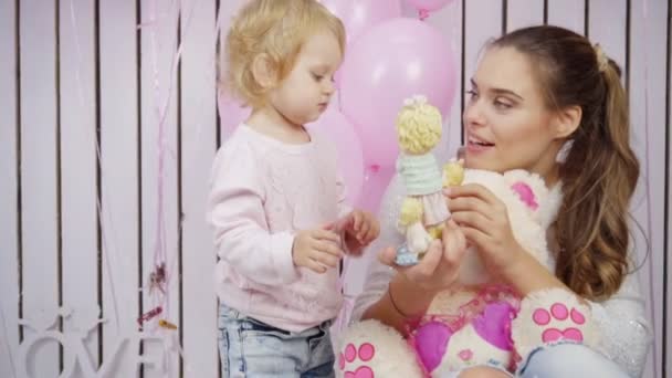 Madre juega con su hija con juguetes y globos en cámara lenta — Vídeo de stock