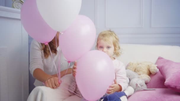 Hija juega con globos de aire divertirse cerca de mamá — Vídeo de stock