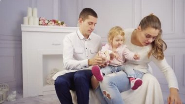 Genç aile ile onların bebek kız evde yangın yerinde oynar.
