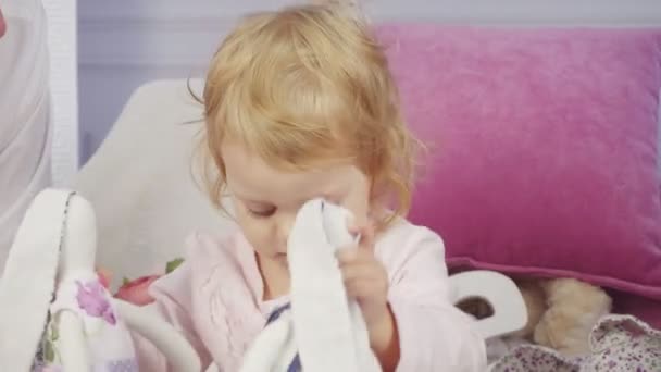 Bebê menina brinca com brinquedos coelhos — Vídeo de Stock