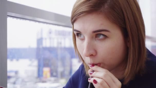 Vrouw dranken met behulp van zaadvormende in de buurt van het venster in slow motion — Stockvideo