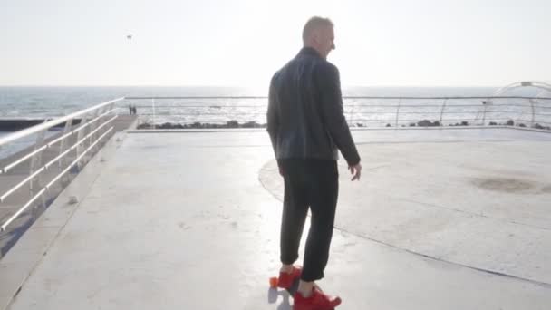 Крутий хлопець на своїх довгоногих ковзанах біля моря — стокове відео