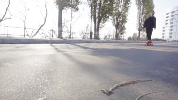 Jovem patina em seu longboard na estrada na cidade — Vídeo de Stock