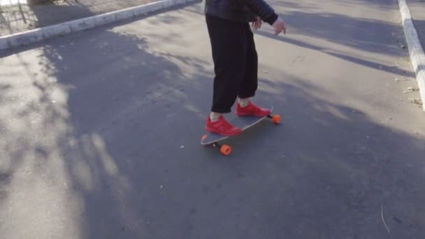 Jovem monta em seu longboard na cidade — Vídeo de Stock