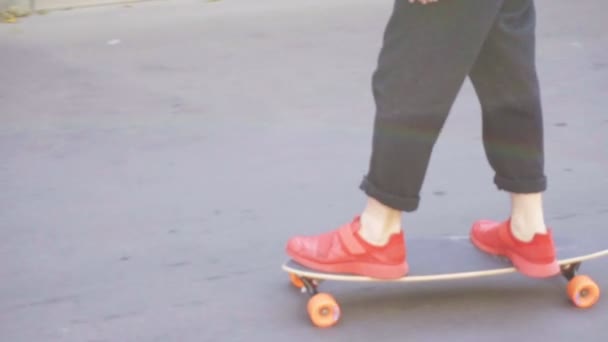 Joven en zapatillas rojas patinaje en la calle — Vídeo de stock