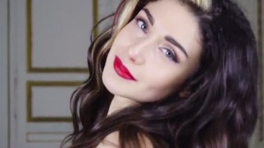 Genç esmer kadın kırmızı dudak ile kameraya benziyor