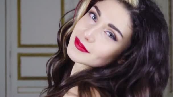 Young brunette woman with red lip looks at camera — Stock Video