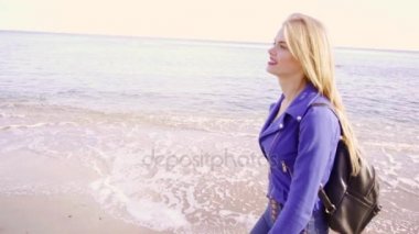 Uzun saçlı sarışın kadın deniz kaymak ile yürüyor