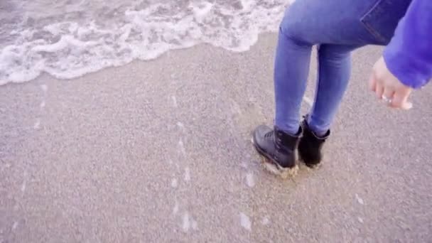 Blondine mit langen Haaren geht am Strand vom Wasser zurück — Stockvideo