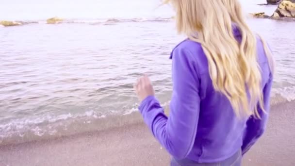 Jeune belle femme blonde passe au bord de la mer — Video