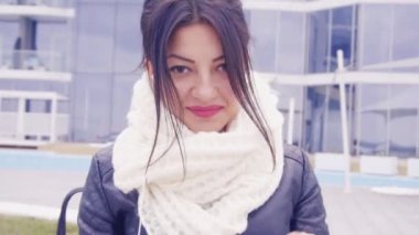 Genç esmer kadın dışında oturur ve kulaklık müzik dinler