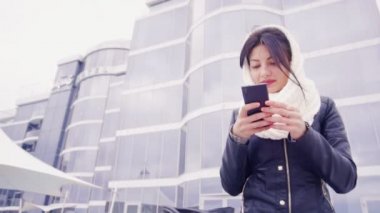 Telefonuyla ilgili dışında genç esmer kadın oturur