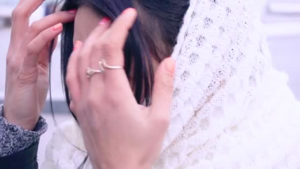 Женщина в шарфе подбирает волосы — стоковое видео