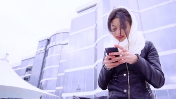 Jeune femme brune s'assoit dehors avec son téléphone — Video