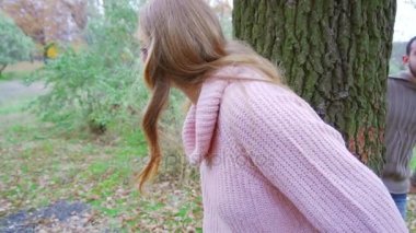 Ormanda saklanıyor ve oynayan eski ağaç karşı yaslanmış çekici sarışın kız