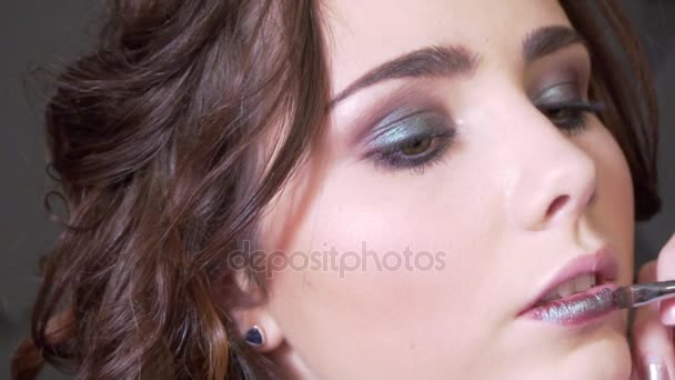 Kadeřnice dělá make-up krásná žena ve studiu s vlnitý účes