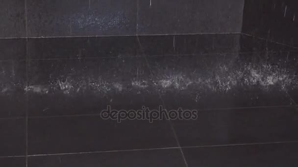 Σταγόνες νερού που πέφτουν στο τα μαύρα πλακάκια στο πάτωμα — Αρχείο Βίντεο