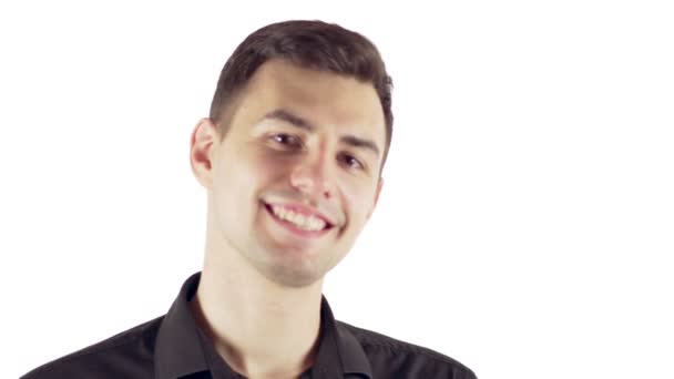 Bello giovane uomo in camicia nera sorridente mentre in piedi isolato su sfondo bianco — Video Stock