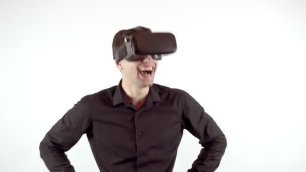 Homem rindo em seus óculos de realidade virtual. Estúdio de vídeo, fundo branco — Vídeo de Stock