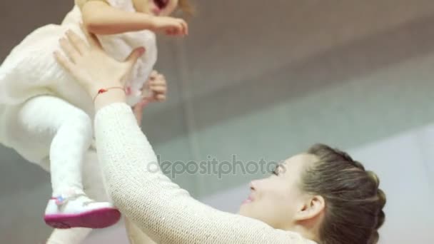 Lycklig mamma och hennes lilla dotter spelar. Mor kastar upp dotter. — Stockvideo