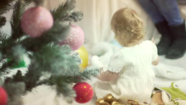 Νεαρή μητέρα παίζει με το μωρό κορίτσι κάτω από το χριστουγεννιάτικο δέντρο. Περίοδο των διακοπών. Χρόνος οικογένεια. — Αρχείο Βίντεο