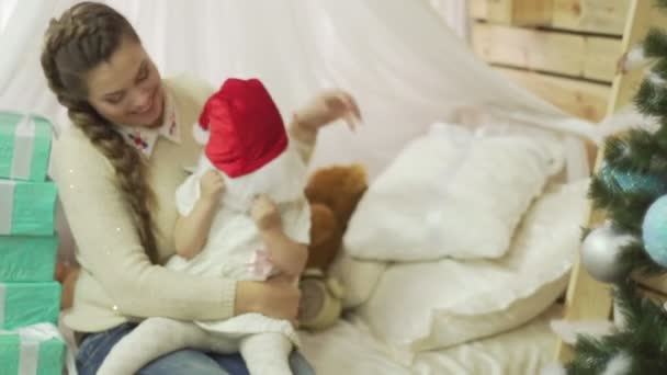 Joyeux jeune mère avec son doux bébé jouant près de l'arbre de Noël — Video