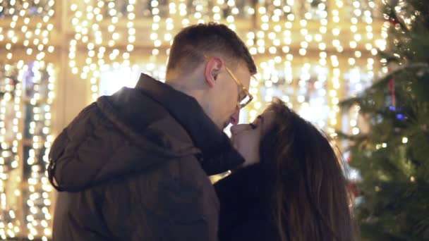 年轻快乐的吸引力夫妇接吻和附近圣诞树上跳舞。圣诞节的时候 — 图库视频影像