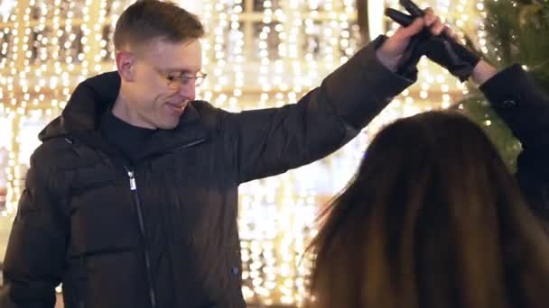 행복 한 매력적인 커플 크리스마스 시장에서 새 해 트리 근처 밤에 춤. 아름 다운 빛 배경. — 비디오