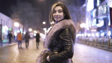 Genç güzel kadın gülümseyerek ve City karşı akşam ışıklar gece sokak poz güzel