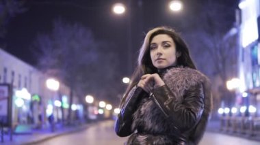 Genç güzel elleri Isıtma ve birilerinin City karşı akşam ışıklar gece sokak bekliyor kadın güzel