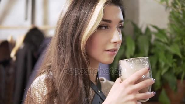Beautiful Girl Drinking Cacao or Coffee in Cafe. Beauty Model Woman with the Cup of Hot Beverage. Spruces branches at the background — Stock Video