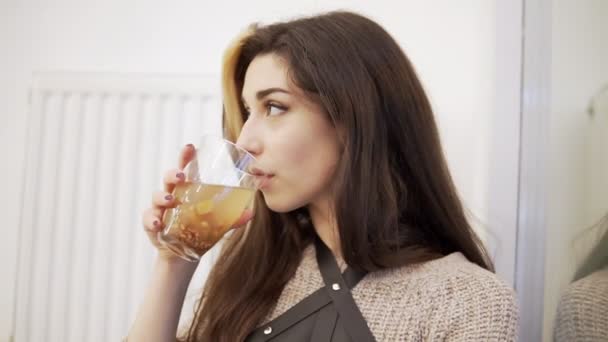 Bonita joven morena bebe del vaso junto a la ventana — Vídeos de Stock