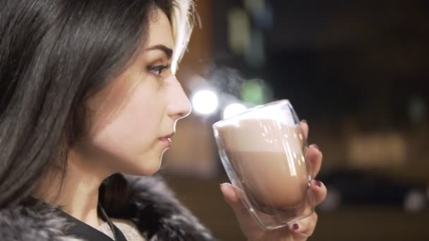 Primer plano retrato de una joven morena con una taza grande de bebida caliente durante el día frío . — Vídeos de Stock