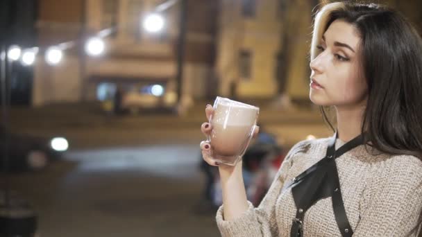 Primer plano retrato de una joven morena con una taza grande de bebida caliente durante el día frío . — Vídeos de Stock