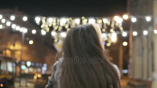 Ung vacker ganska kvinna promenader och leende på city gatan i natt mot kvällen lampor — Stockvideo