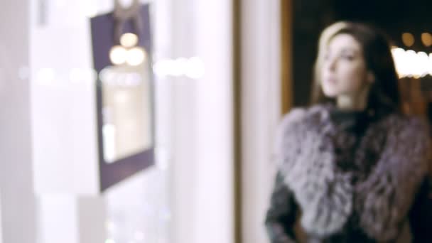 Winter dressed lady stands in front of the window display of expensive boutique store. Come into focus — Stock Video