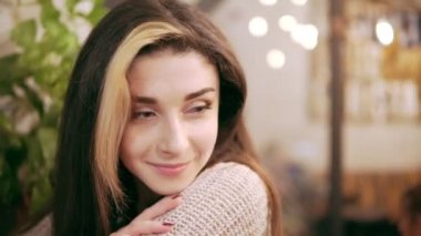 Sıcak kakao içmeye dekore edilmiş bir kafede oturan güzel genç esmer kadın