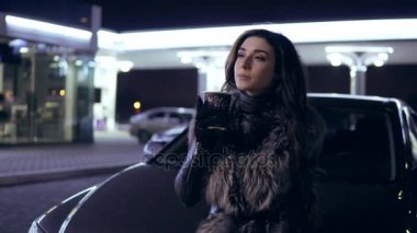 Genç güzel esmer kadın ceket içecekler sıcak içecek araba kukuleta oturan