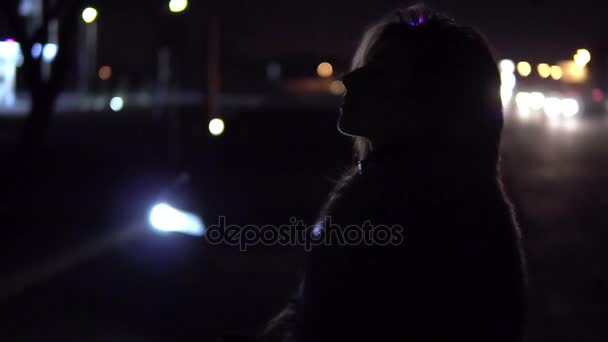 Девушка, стоящая на улице возле машины ночью . — стоковое видео