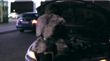 Genç kız ile telefonda konuşurken açık kukuleta kırık araba yanında yardım bekliyor sinirli