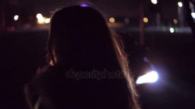 Sokak gece şehrin genç esmer kız arabaya gelmek yukarıya. Trafik ışıklarında backstage.