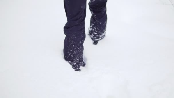 Hombre caminando en zapatos de snowboard en la nieve — Vídeos de Stock