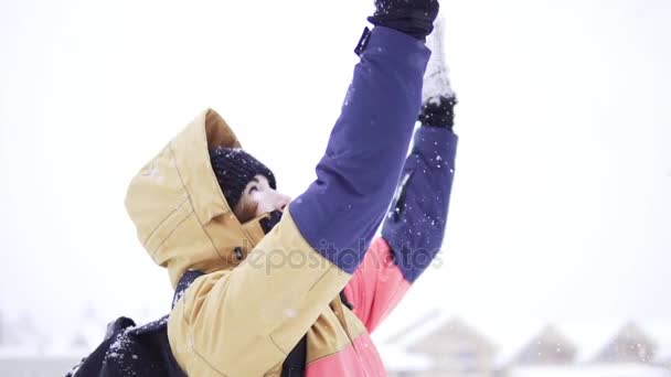 Gelukkig schattig meisje speelt met sneeuw buiten, het overgeven met handen en mooie vrouw die lacht met wapens aan de blauwe hemel opgefokt zijn en natuur, jonge tiener vrouwelijk in kleurrijke jas, kerst winter vakantie — Stockvideo