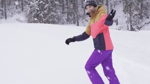 Junge Frau spielt im Schnee und ruft, zu folgen — Stockvideo