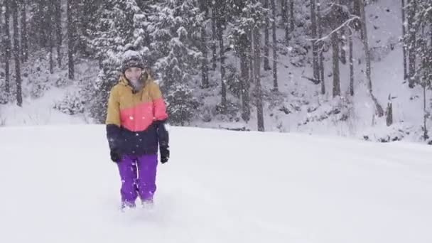 Mladá žena běží na sněhu v zimním oblečení — Stock video